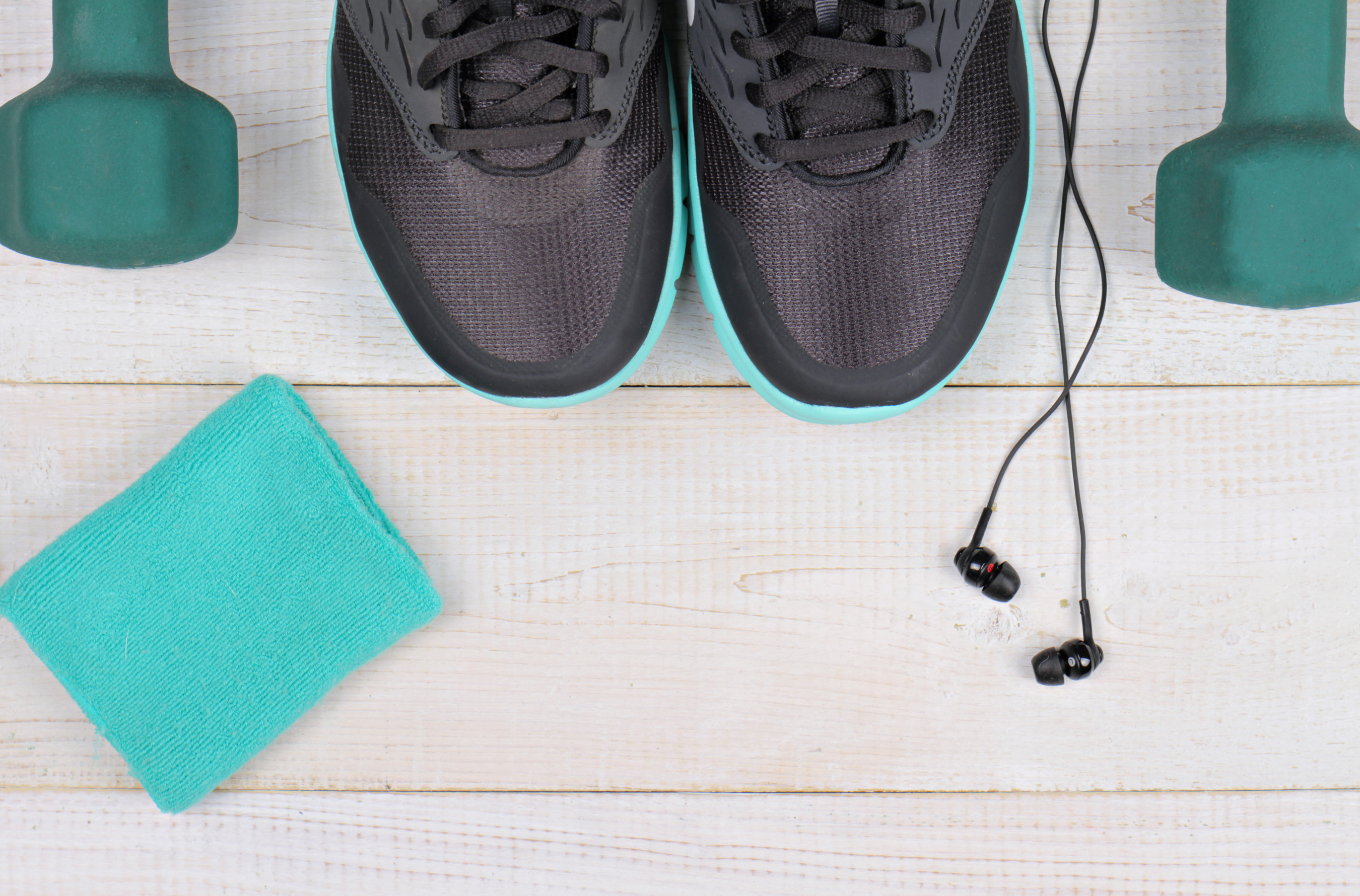 Woman workout concept. Fitness background. Sport shoes, dumbbells, earphones on white background